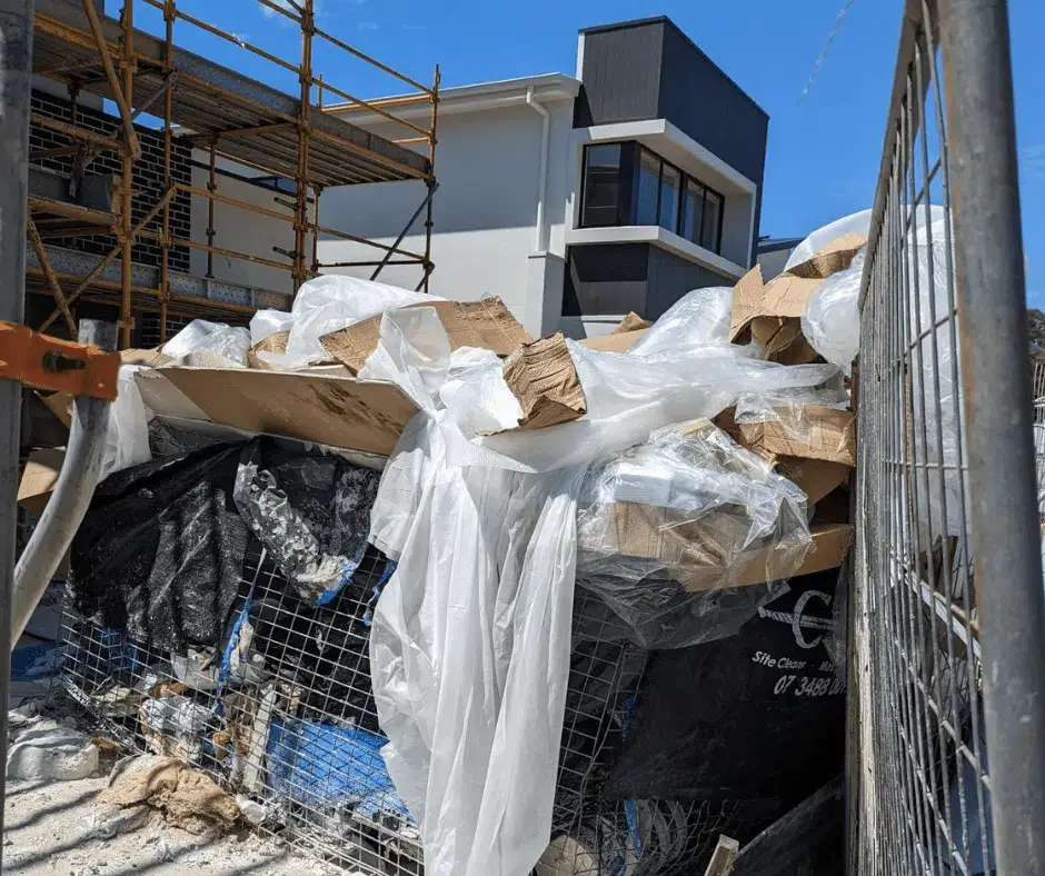 Rubbish cage on a work-site overflowing with trash, showing the difference between skip bins vs rubbish cages